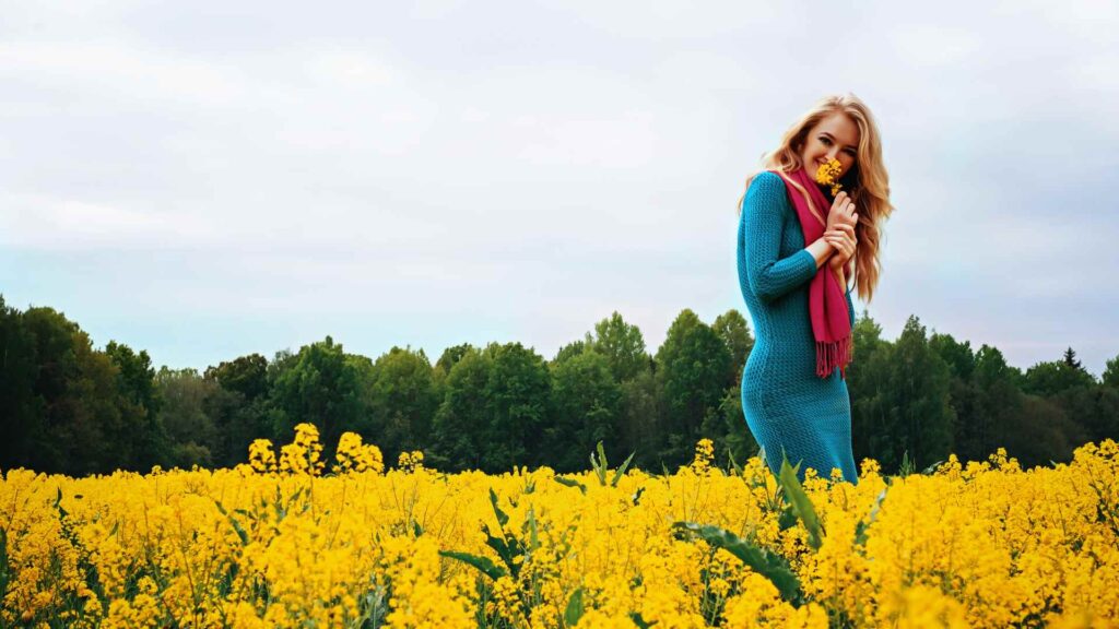 a woman standing in a field of yellow flowers